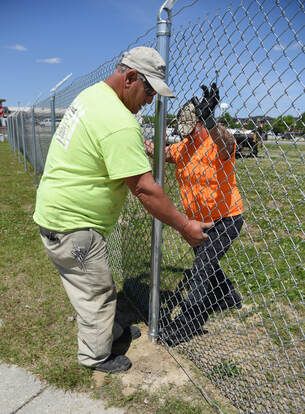 Fence contractors installing a chain link fence